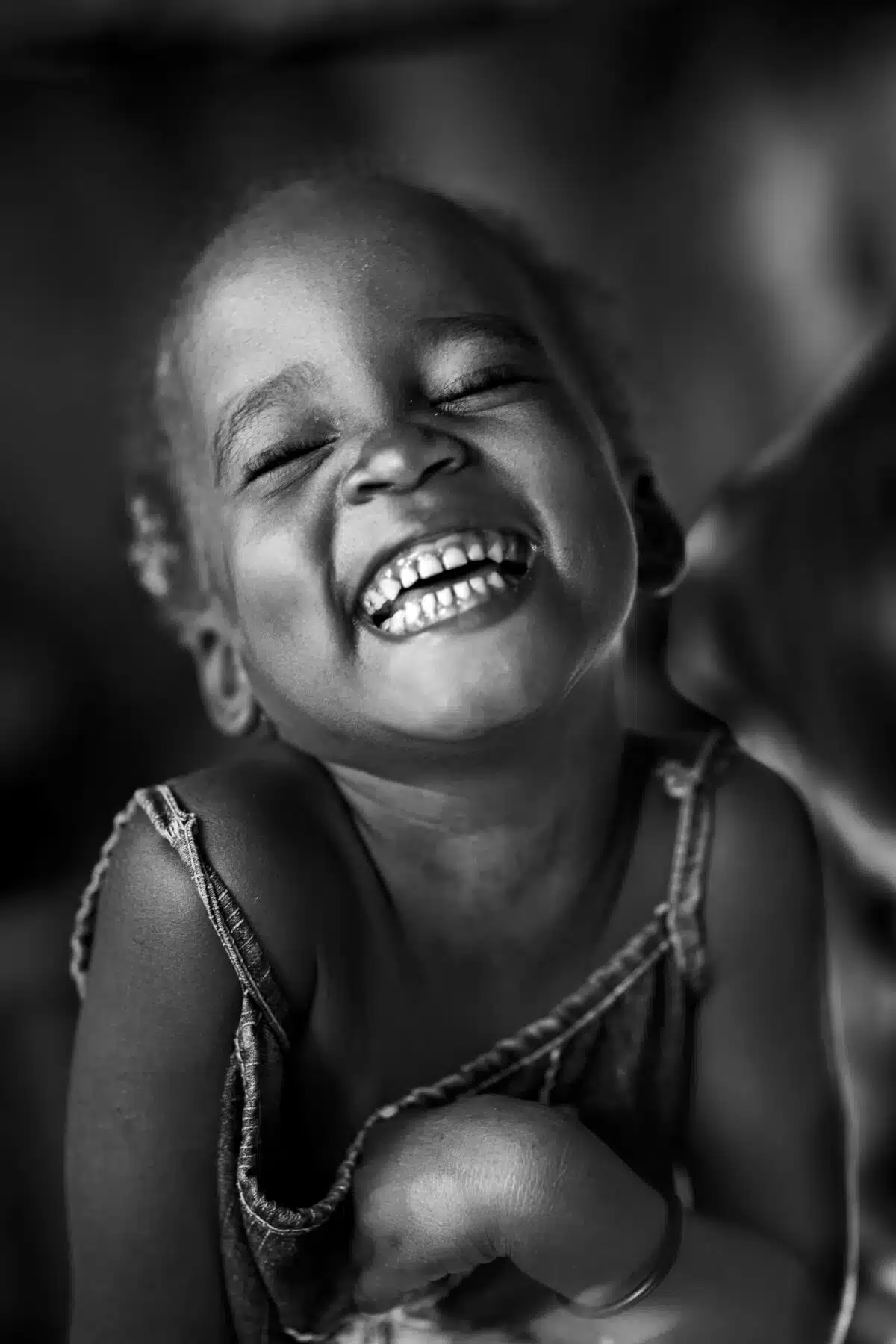 Young girl in Cité Soleil, in Haiti giggles with joy despite her impoverished surroundings.