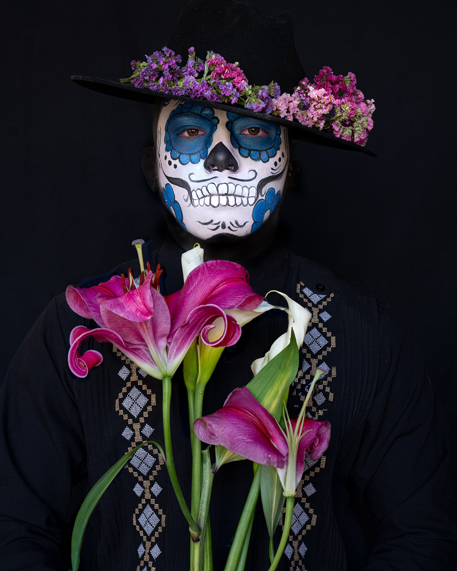 This man in Oaxaca captures Día de los Muertos, honoring departed loved ones with vibrant face paint, rituals, and floral tributes.